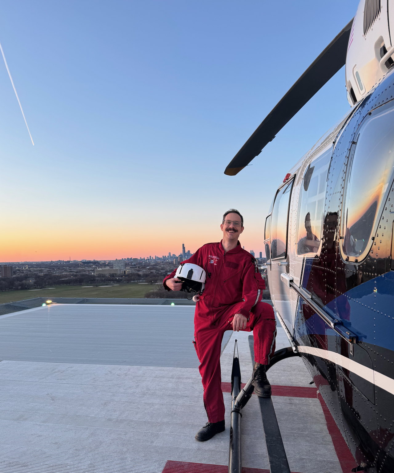 Bradley beside a medical helicopter at sunset